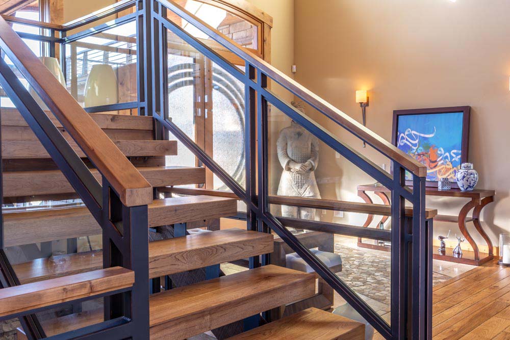 Staircase with custom railings wood beam steps.