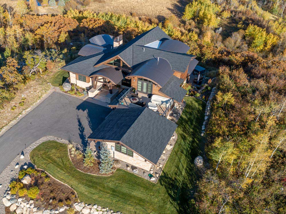 Arial view looking down on custom mountain home with round roof lines.