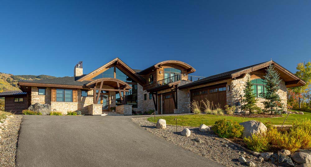 Stone home with wood accents and three car garage.