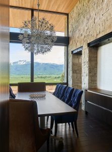Dining room with full stone wall and large window with mountain views.
