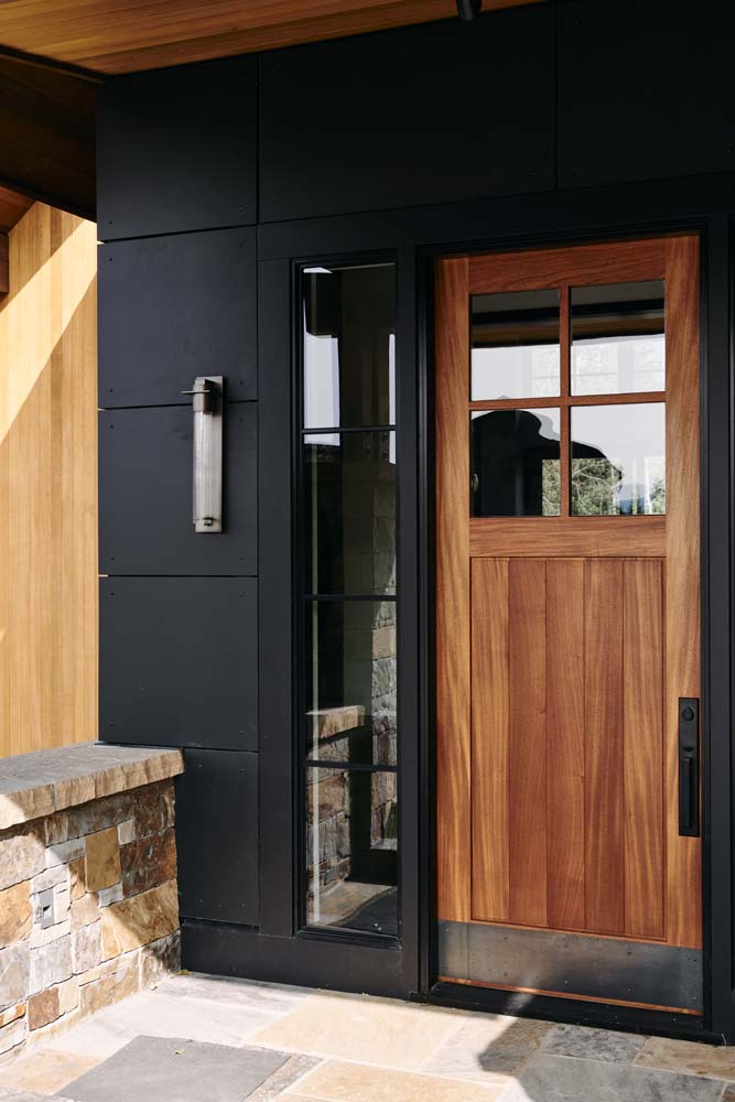 Outside entry painted black with a wood door.