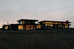 Large modern home at dusk lit up from the inside.